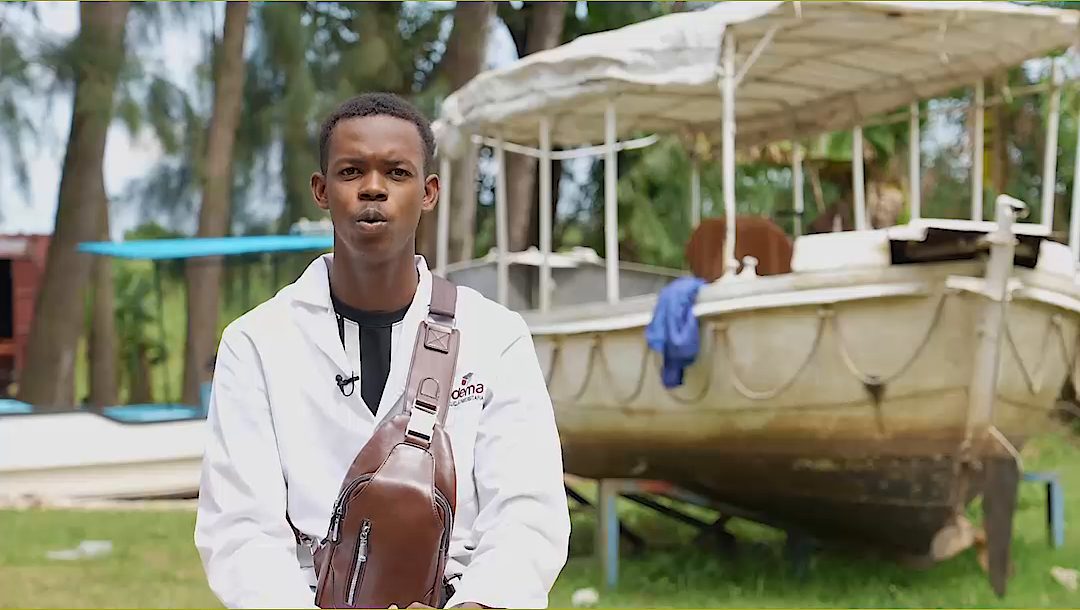 A KEMFSED beneficiary by the boats